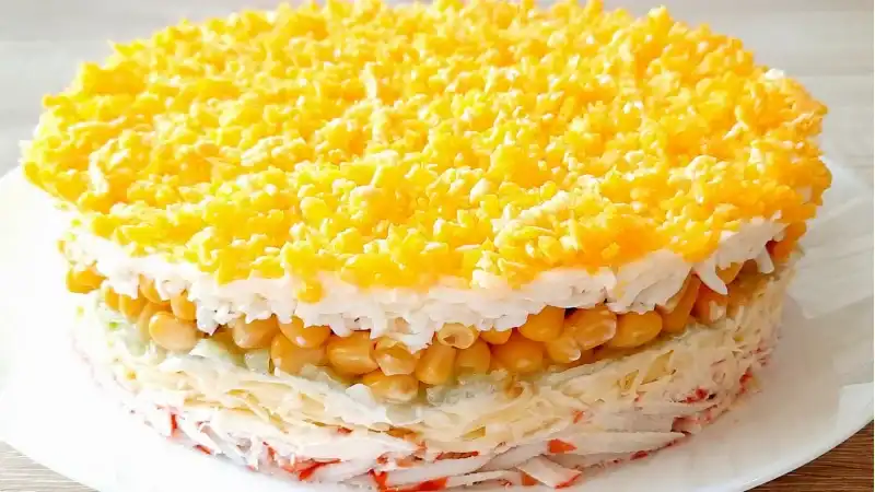 Вкусный слоёный салат с крабовыми палочками и кукурузой готовится быстро и просто.